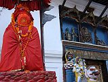 Kathmandu Durbar Square 06 03 Hanuman Statue And Entrance Gate Stone lions flank the sides of the Hanuman Dhoka gate in Kathmandu�s Durbar Square, one ridden by Shiva, the other by his wife Parvati. Above the gate a brightly painted niche is illustrated with a central figure of a ferocious Tantric version of Krishna. On the left side is the gentler Hindu Krishna in his traditional blue colour accompanied by two of his comely milkmaids. On the right side are King Pratap Malla and his queen.